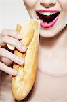 Young woman biting baguette