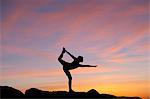 Young woman in dancer pose in desert, silhouette