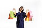 Portrait de jeune femme posant avec les sacs à provisions