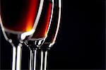 Close-up of three glasses of wine against black background