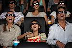 Family watching 3-D movie in theater