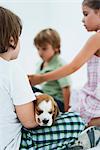 Children hanging out, boy in foreground holding beagle puppy