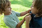 Boys fighting, one gripping the other's shirt