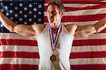 Male medalist in front of American flag