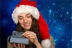 Young woman wearing Santa hat, opening Christmas gift