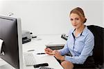 Jeune femme assise au bureau dans le bureau