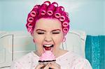 Young woman with open mouth holding cupcake