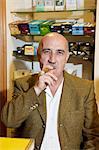 Portrait of mature tobacco store owner smoking cigar