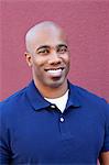 Portrait of a happy bald African American male over colored background