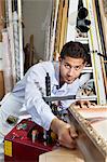 Portrait of a confident craftsman working on picture frame