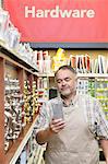 Mature salesperson reading something in hardware store