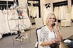 Portrait of a happy woman making a call in bridal store