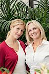 Portrait of happy mother and daughter in greenhouse