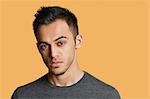 Portrait of a confident young man over colored background