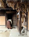 Korean woman cleaning a traditional house at Suwon Folk Village, South Korea