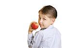 Boy holding an apple looking over his shoulder.  You could replace the apple with another item.