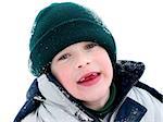 Young boy having fun with snow outdoors in winter, front teeth missing