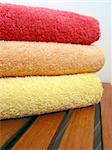 Stack of bright colorful clean towels on a wooden bench