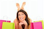 A picture of a pretty young woman lying among shopping bags over white background