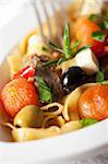 closeup of pasta with tomatoes and olive