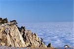 Sunlit cliffs and sea in clouds. Crimean mountains.
