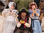 Three people with guns out in old American west scene