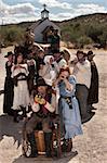 People in American old west scene with weapons in front of church