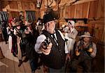 Serious man with old west gang holding guns