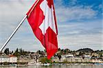 Swiss Flag on the Background of the Embankment of the River Reuss in Lucerne