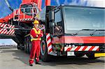 Crane driver, posing next to the huge mobile crane he's operating