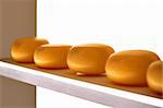 round yellow cheese on display on shelf