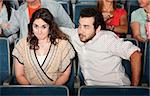 Guy in beard flirts with young woman in theater