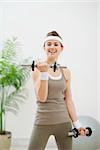 Healthy athletic woman making exercise with dumbbells