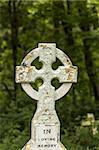 Old stone cross in Graveyard with writing