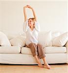 cute young girl relaxing and stretches on couch at home