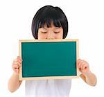 7 years old pan Asian school girl covered her mouth with blackboard on white background