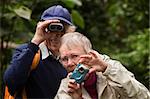 Concerned woman with camera and happy man with binoculars