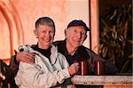 Smiling senior couple with coffee mugs in jackets