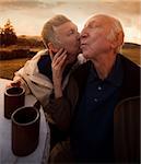 Nice senior woman kisses her husband outside