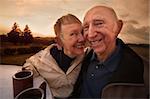 Close mature couple outside with coffee mugs