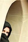 Cautious Islamic Woman in a Window Pane Wearing Traditional Burqa or Niqab.