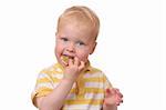 Portrait of a young kid eating cookies on white background