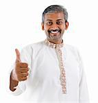 Excited thumb up Indian man in traditional costume kurta dhoti isolated on white background