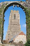 The present day Church of St Andrew, at Covehithe,  Suffolk, England, viewed through the arch of its predecessor, now in ruins.