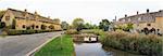 panorama of the river eye winding through the quaint village of lower slaughter in oxfordshire england past cottages built in traditional cotswalds stone