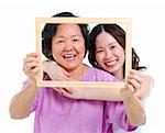 Mixed race Asian senior mother and adult daughter looking fun through an empty frame