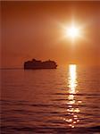 An image of a cruise ship in the sunset