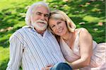 Old people and romance, elderly husband and wife in love, lying on grass in park