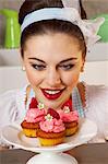 Une fille de style rétro avec des muffins aux fraises