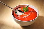 A bowl of tomato soup with a spoon